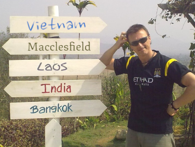 Martin profile picture standing next to a direction sign showing Vietnam, Laos, India and Thailand