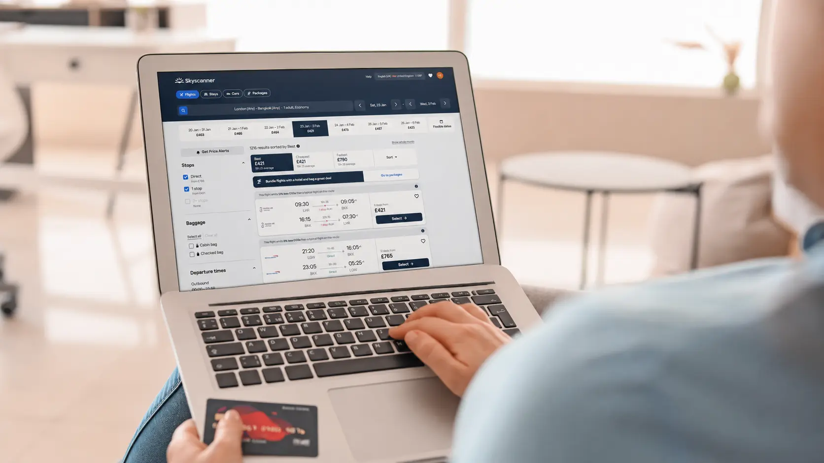 A traveller searching for flights on a laptop